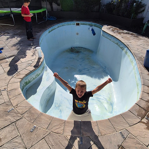 child in empty home pool